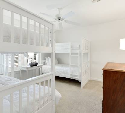Your family will love this bright bunk room with crisp white beds, soft carpeting, and thoughtful touches like fresh greenery.