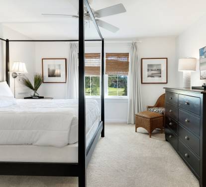 Unwind in your elegant master bedroom with a luxurious four-poster bed, crisp linens, and peaceful garden views through bamboo blinds.
