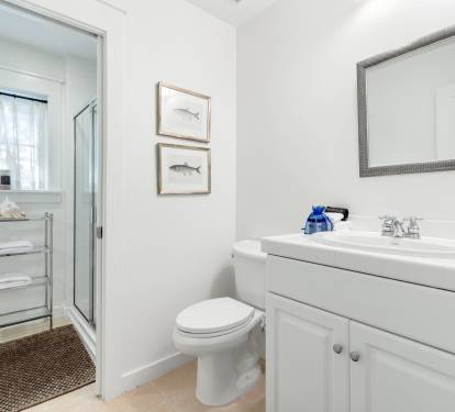 Refresh in your pristine bathroom with coastal charm, featuring a spacious vanity, glass shower, and thoughtful touches that make your morning routine feel luxurious.