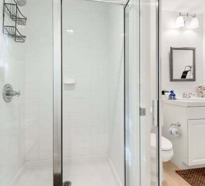 Step into your pristine bathroom featuring a spacious glass shower, modern vanity, and thoughtful touches that make your morning routine feel luxurious.