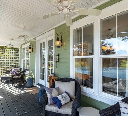 Unwind on your private covered porch with cozy wicker seating and gentle ceiling fans creating the perfect lakeside retreat.