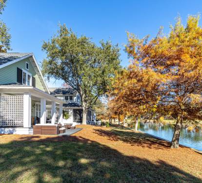 Charming lakefront cottage surrounded by vibrant autumn foliage and peaceful waterfront setting.