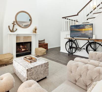 Cozy up by your crackling fireplace in this stylishly furnished living room, complete with plush seating and modern entertainment setup.