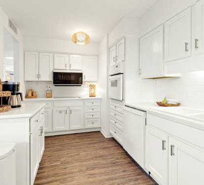 Your bright, fully-equipped kitchen awaits with crisp white cabinets, modern appliances, and ample counter space for preparing memorable meals.