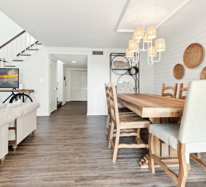 Unwind in your stylish open-concept living space with warm wood floors, coastal decor, and everything you need for memorable meals together.