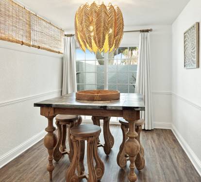 Gather around this elegant dining table with its striking feather chandelier, where your meals become memorable moments in this beautifully appointed space.