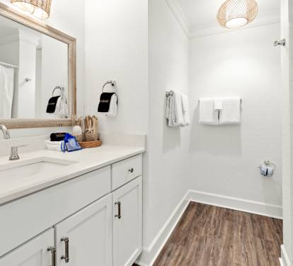 Your bright, spa-like bathroom features marble tile, a rainfall shower, and woven pendant lighting for ultimate relaxation.