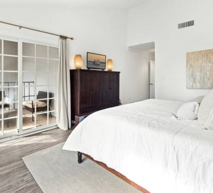 Sink into crisp white linens in your serene bedroom, where French doors open to your private balcony for morning coffee moments.