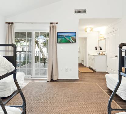 Relax in your comfortable bunk room with crisp linens, natural light, and modern amenities perfect for a restful stay.