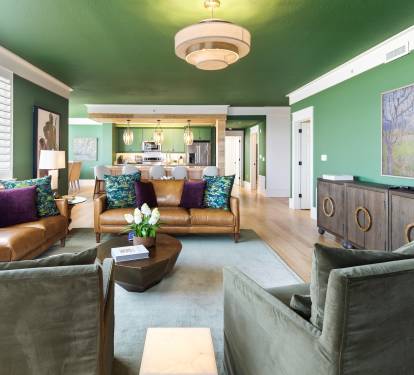 Sink into luxurious leather seating surrounded by vibrant emerald walls and artistic touches that create your perfect urban retreat.