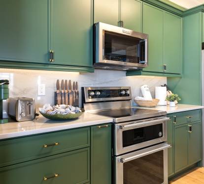 Cook memorable meals in this stunning sage green kitchen with premium stainless steel appliances and elegant quartz countertops.