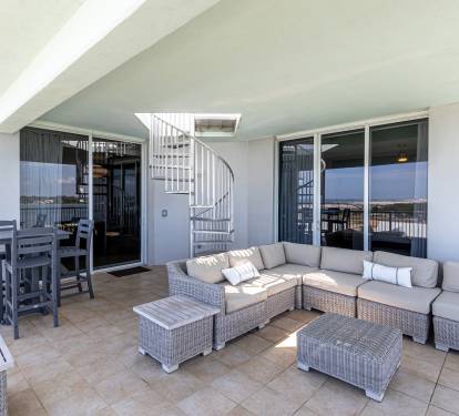 Unwind on your private terrace with panoramic views, plush wicker seating, and seamless indoor-outdoor living through floor-to-ceiling windows.
