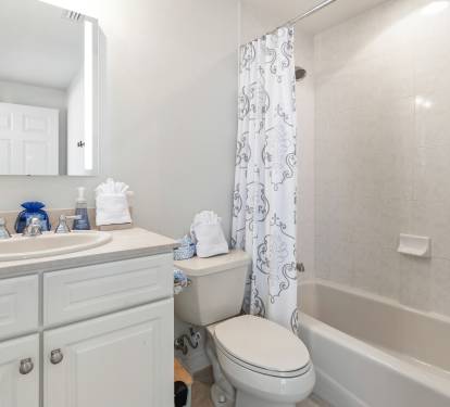 Your bright bathroom features a relaxing tub-shower combo with elegant tiled walls and fresh towels waiting for you.