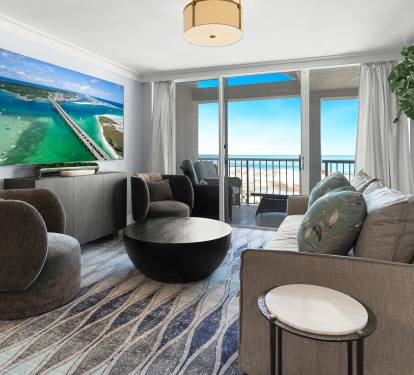 Sink into plush seating while ocean breezes drift through your private balcony doors, where stunning sea views create the perfect backdrop for relaxation.