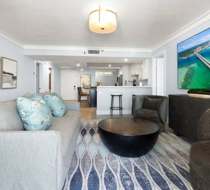 Relax in your bright living space with coastal views, comfy seating, and an open kitchen perfect for preparing meals together.