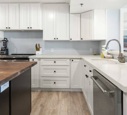 Cook with ease in this bright, fully-equipped kitchen featuring sleek white cabinetry, modern appliances, and ample counter space for your culinary adventures.