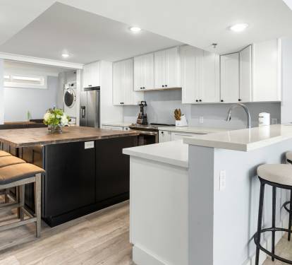 Your modern kitchen invites culinary adventures with sleek white cabinets, quartz countertops, and a spacious island perfect for morning coffee or evening gatherings.