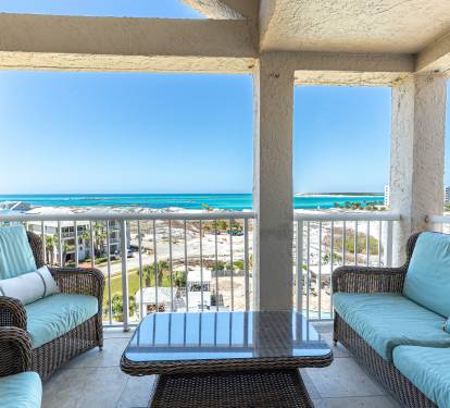 Sink into plush wicker seating on your private balcony, where turquoise waters and endless blue skies create your perfect coastal retreat backdrop.