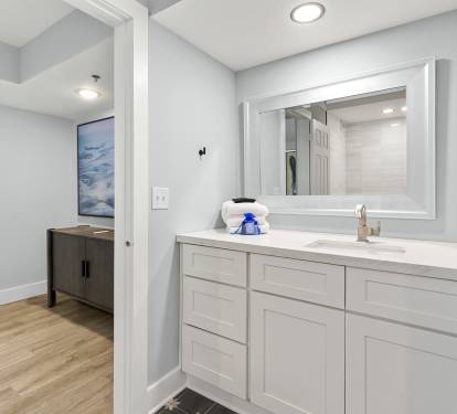 Your pristine bathroom vanity awaits with crisp white cabinetry and elegant marble countertops, creating a spa-like retreat for your daily routine.