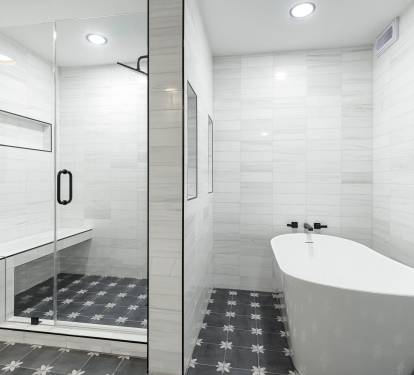 Unwind in your spa-like bathroom featuring a luxurious soaking tub and spacious glass shower with elegant tile work throughout.