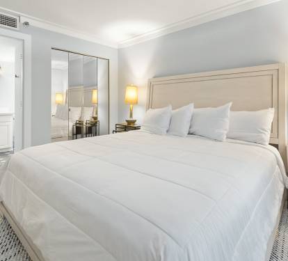 Drift into peaceful slumber on crisp white linens in your elegantly appointed bedroom with soft lighting and modern amenities.