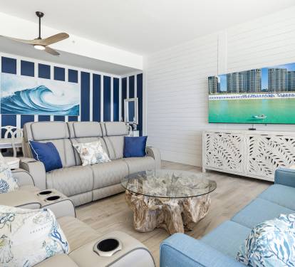 Relax in your coastal-themed living room with ocean wave art and comfortable seating for movie nights.