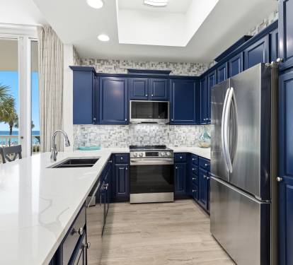 Your spacious kitchen features navy cabinets, gleaming countertops, and ocean views that make meal prep feel like a vacation ritual.