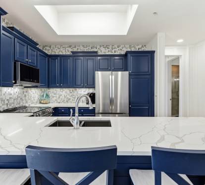 Your gourmet kitchen features elegant navy cabinets, marble countertops, and stainless steel appliances—perfect for preparing memorable meals together.