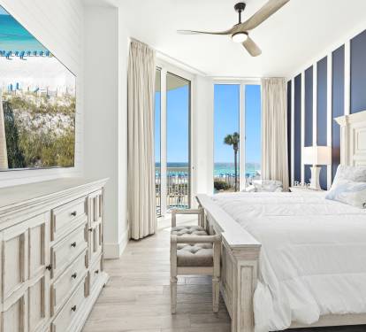 Wake up to stunning ocean views from your bed! This coastal bedroom features crisp white linens and opens to a private balcony overlooking pristine beaches.