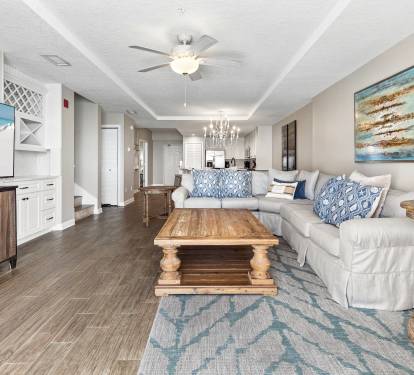 Sink into plush coastal comfort in your open-concept living space, where soothing blues and warm woods create the perfect beach retreat atmosphere.