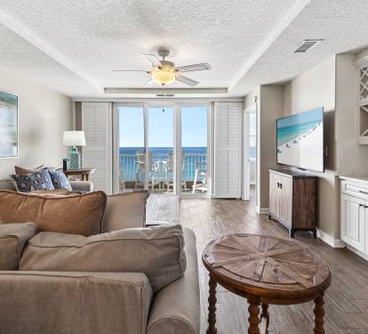 Your spacious living room opens to stunning ocean views through floor-to-ceiling windows, with comfortable seating and coastal-themed décor welcoming you home.
