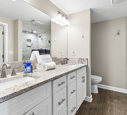 Your spacious bathroom features granite counters, dual sinks, and a luxurious glass-enclosed shower with marble accents for ultimate relaxation.