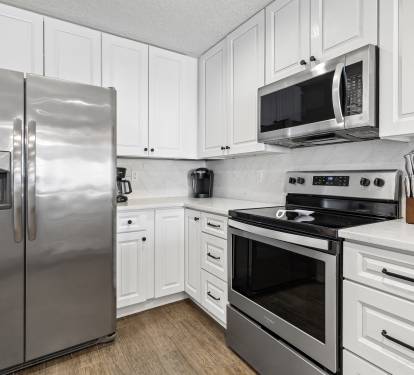 You'll love preparing meals in this modern kitchen with sleek stainless steel appliances and crisp white cabinetry.