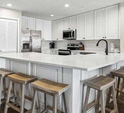 Your spacious kitchen features gleaming quartz countertops, stainless steel appliances, and a breakfast bar where you can enjoy morning coffee together.