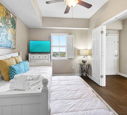 Unwind in your bright, airy bedroom with coastal charm. The plush daybed and cheerful décor create your perfect retreat.