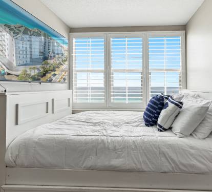 Wake up to stunning ocean views from your comfortable bed, with shuttered windows framing the endless blue horizon.