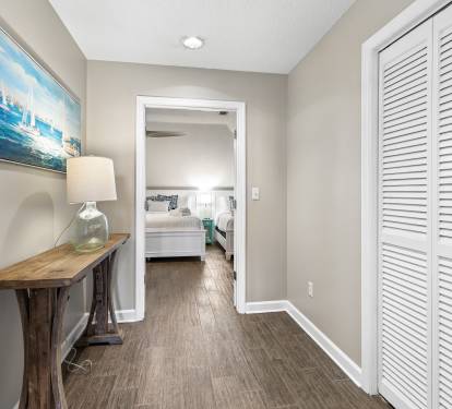 Your bright hallway connects bedrooms with coastal charm, featuring a rustic table perfect for morning coffee before exploring the day.