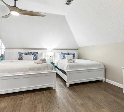 Rest peacefully in your bright upstairs bedroom with twin beds, coastal touches, and a ceiling fan for perfect comfort.