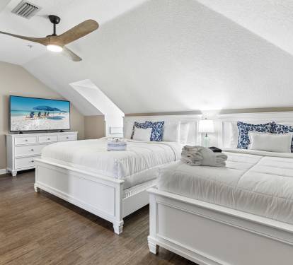 Unwind in your serene twin-bed sanctuary with crisp linens and coastal charm beneath gentle ceiling fan breezes.