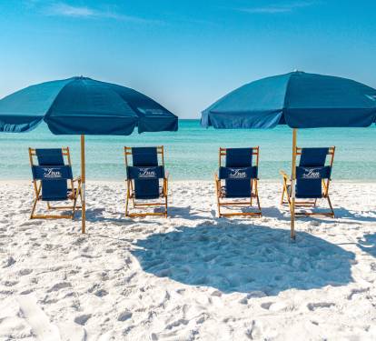 Pristine beach with white sand, turquoise waters, and luxury umbrella service for ultimate relaxation.