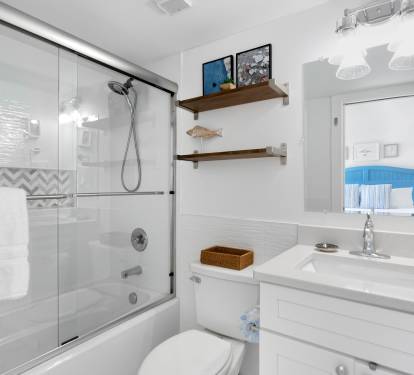 Unwind in your pristine bathroom featuring a luxurious soaking tub, refreshing walk-in shower, and thoughtful coastal touches that make every moment feel like a spa retreat.