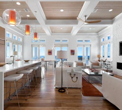 Relax in this stunning open-concept space where modern kitchen flows into elegant living area with fireplace and gulf views.