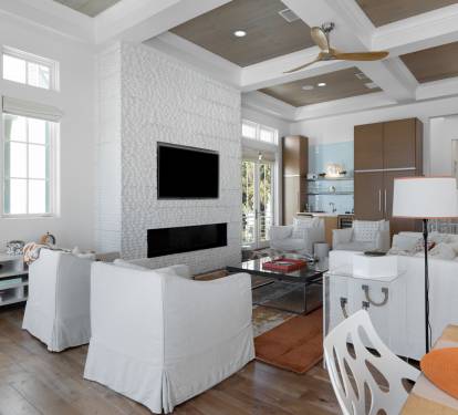 Unwind in your elegant living room featuring a cozy fireplace, modern entertainment center, and coffered ceiling that creates the perfect atmosphere for relaxation.