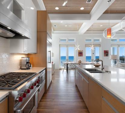 Your gourmet kitchen awaits with professional-grade appliances and stunning gulf views through floor-to-ceiling windows.
