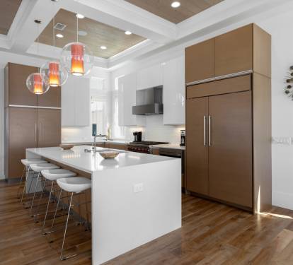 Your stylish kitchen features sleek wood cabinetry, pristine white countertops, and modern pendant lighting for memorable meal prep.