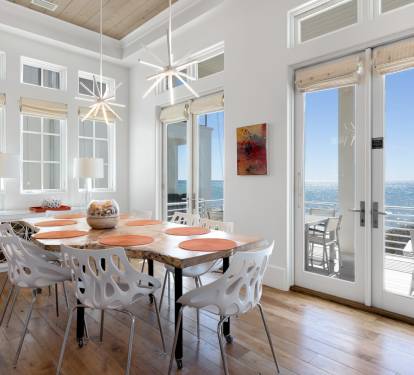 Gather around this stylish dining table where natural light floods through expansive windows, creating the perfect backdrop for memorable meals with sweeping views.