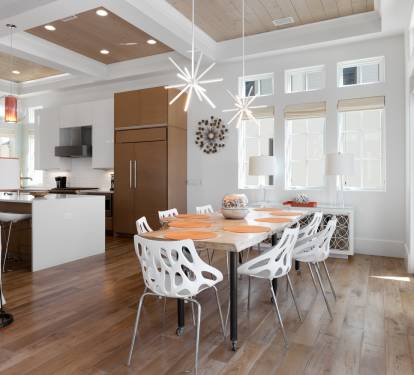 Gather around this stunning modern dining table where memorable meals unfold beneath elegant pendant lighting and soaring coffered ceilings.