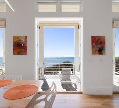 Your bright dining space opens to stunning gulf views through floor-to-ceiling doors, creating perfect indoor-outdoor flow.