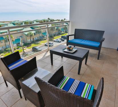 Your private balcony with comfortable seating overlooks the charming neighborhood and features a coffee table perfect for morning drinks or evening relaxation.