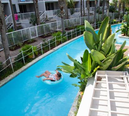 Float peacefully down your private lazy river, surrounded by tropical palms and white sun loungers.